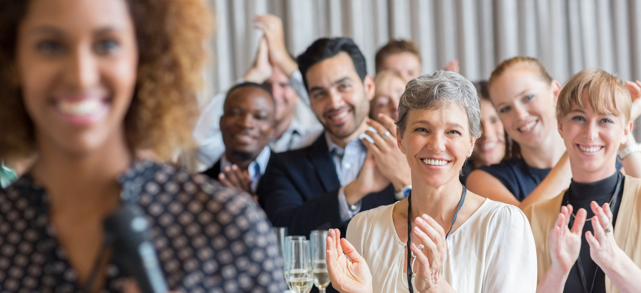 A group of teachers applauding the speaker who is out of focus in the front