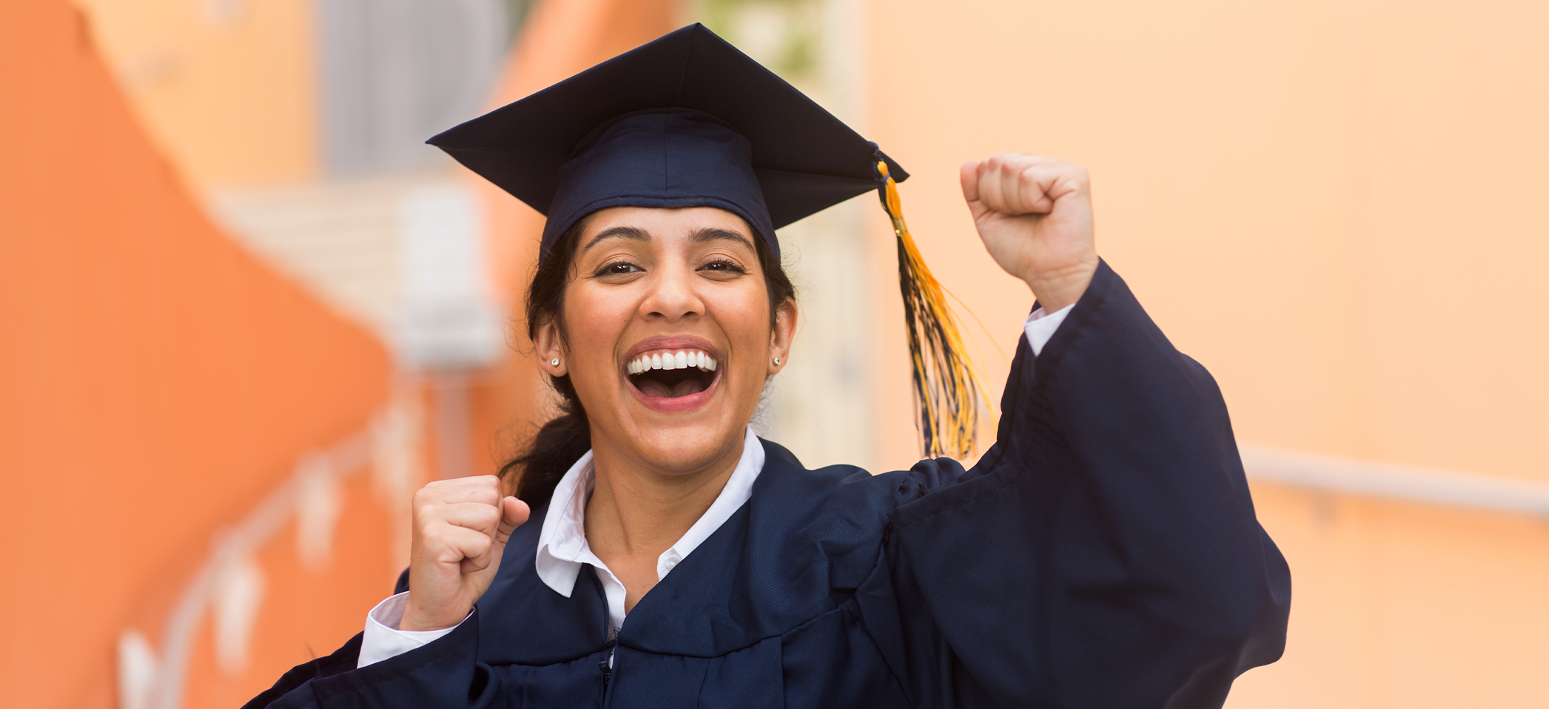 Young Female graduate celebrating in her robe and hat