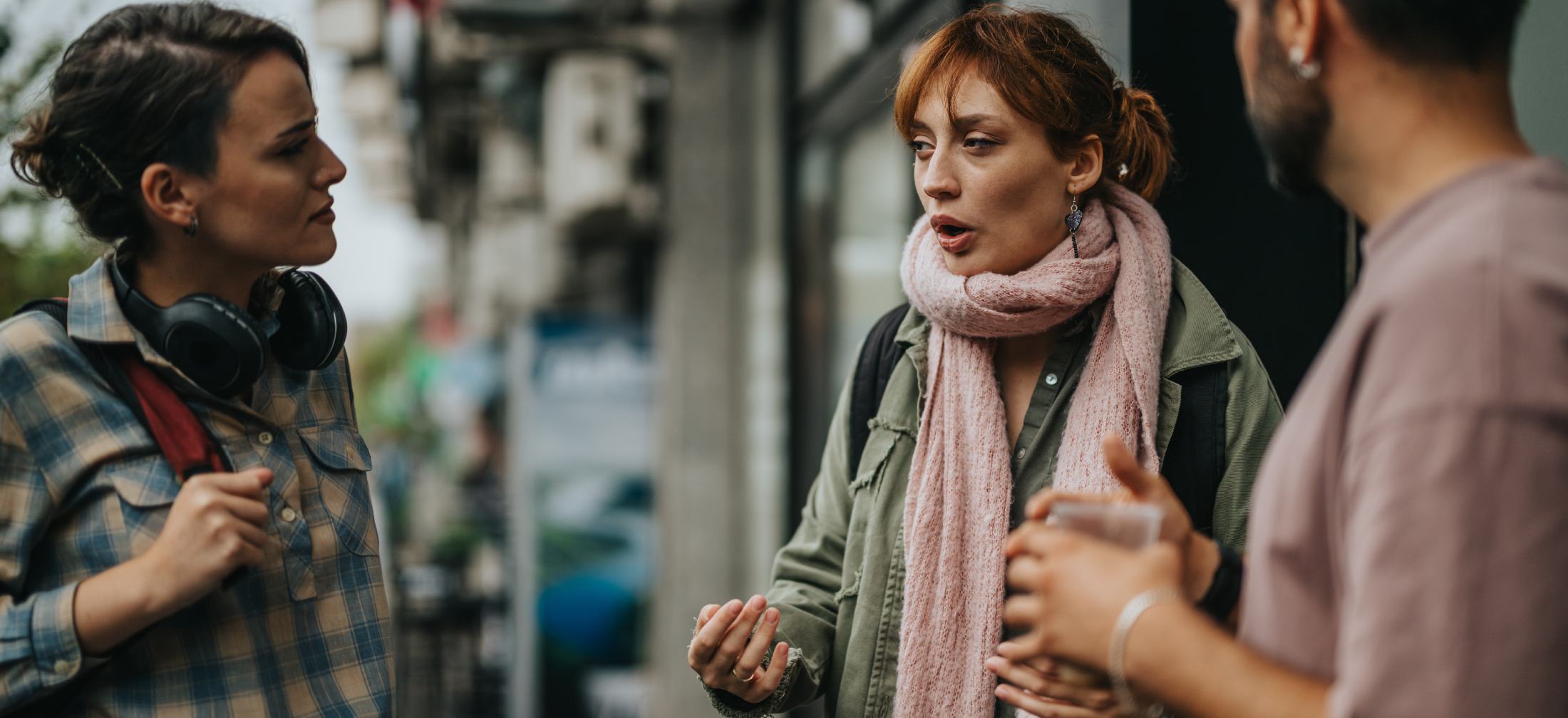three people on sidewalk conversing